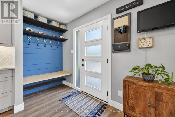 Interior entryway with a blue accent wall, wooden bench, and grey cabinets. - 1959 Snow Valley Road, Springwater