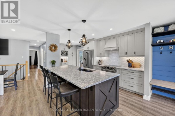 Kitchen with a large island, grey cabinets, stainless steel appliances, and pendant lights. - 1959 Snow Valley Road, Springwater