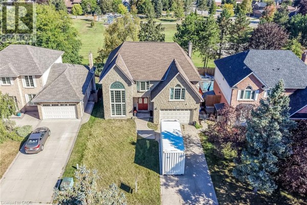 Front view of a two-story stone house with a manicured lawn and driveway. - 196 Bluebell Crescent, Ancaster