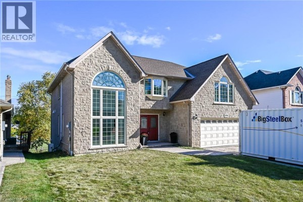 Exterior of a large stone house with a double garage and arched windows. - 196 Bluebell Crescent, Ancaster