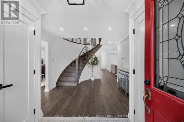 View of the entrance foyer with a curved staircase and dark wood floors. - 196 Bluebell Crescent, Hamilton