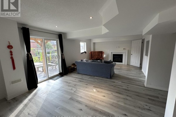 A dining area with a table and chairs, overlooking a spacious living room with a fireplace. - 196 Colesbrook Road, Richmond Hill