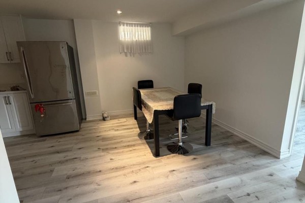 A large, open living space with a sliding glass door revealing a patio and garden area. - 196 Colesbrook Road, Richmond Hill