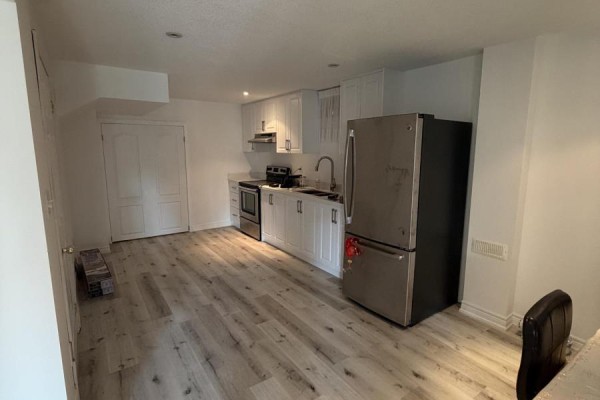 A bedroom with a bed, white walls, and light wood-look vinyl flooring, with an open doorway. - 196 Colesbrook Road, Richmond Hill