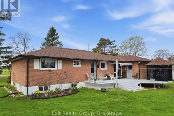 Rear view of brick house with a multi-level deck, gazebo, and backyard. - 196 Elmwood Drive, Belleville