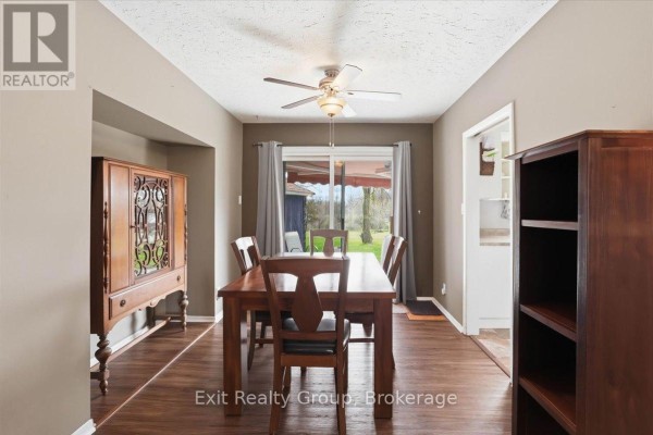 Dining room with wood table and chairs, glass door leading outside. - 196 Elmwood Drive, Belleville
