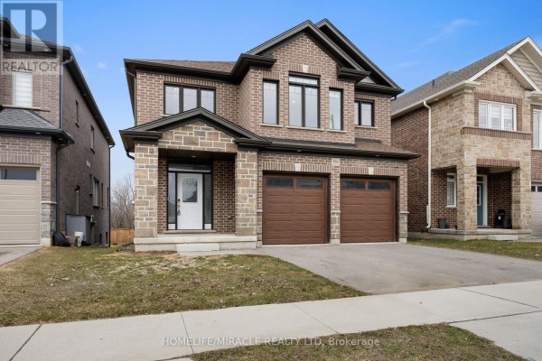 Front view of a two-story brick house with double garage and porch - 196 Freure Drive, Cambridge