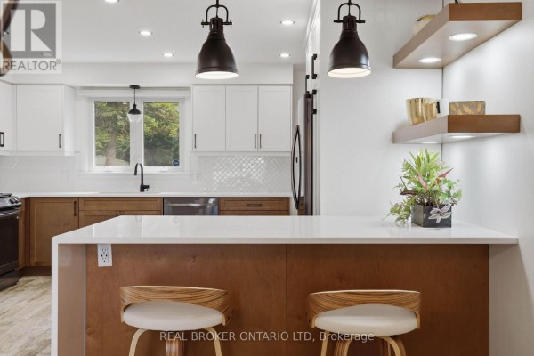 Dining space with wall art, bar seating, and open layout to kitchen. - 196 Wychwood Park, London North