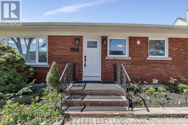 Close-up view of the red brick bungalow's front entrance with a white door and frosted glass. - 1960 Othello Avenue, Ottawa