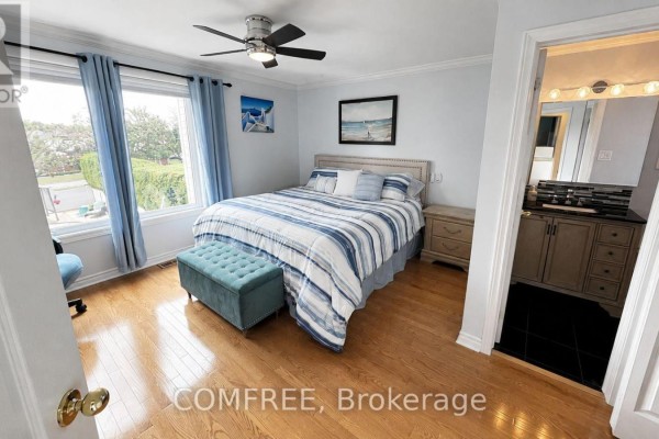 Bedroom with king bed, blue decor, and ensuite bathroom - 1960 Rolling Brook Drive Ottawa