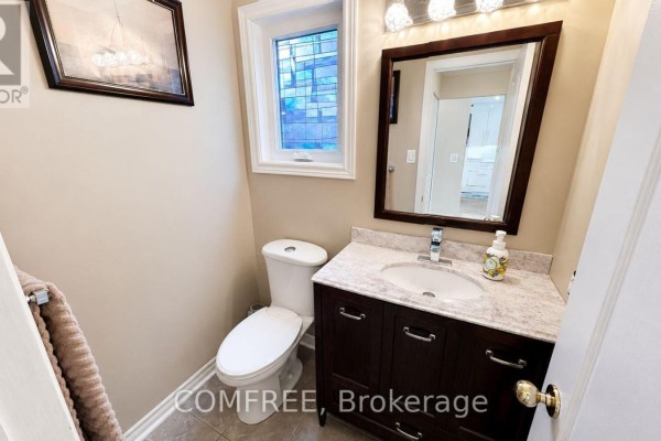 Bathroom vanity with marble countertop and modern faucet, toilet, and stained glass window - 1960 Rolling Brook Drive Ottawa