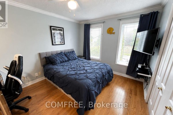 Bedroom with king bed, desk, gaming chair, and wall-mounted TV - 1960 Rolling Brook Drive Ottawa