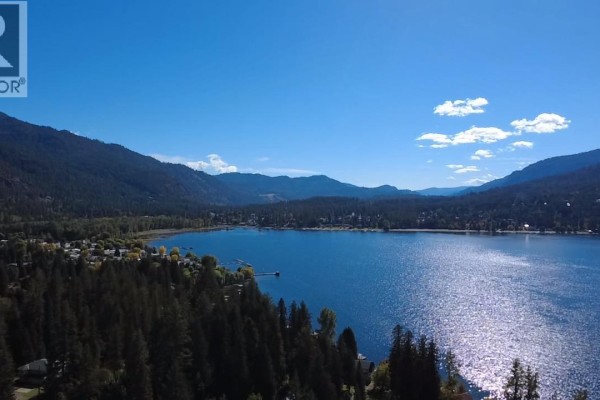 View of Christina Lake and surrounding mountains from a forested hillside on a clear, sunny day. - 1962 Tambellini Road, Christina Lake