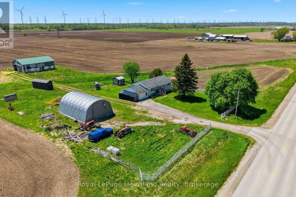 Aerial view of the property showing house, outbuildings, fields, and wind turbines. - 1965 Bruce Road 20 Road, Kincardine