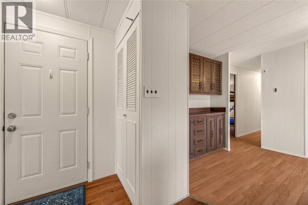 Interior view of a white front door and a tall bi-fold closet next to it. - 197 Dauphin Avenue Unit# 207, Penticton