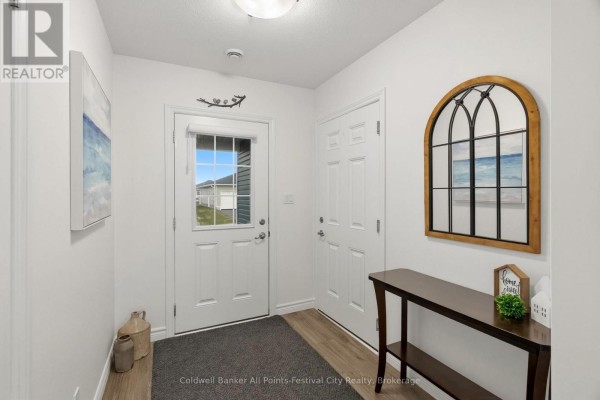 Interior entryway with white walls, white doors, a dark console table, and a decorative arched window. - 197 Lake Breeze Drive, Ashfield Colborne Wawanosh