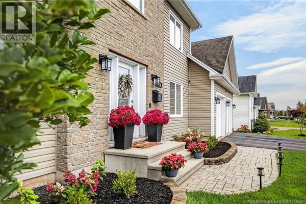 Close-up of the front entrance steps with stone facade, planters, and decorative walkway. - 197 Mailhot Avenue, Moncton