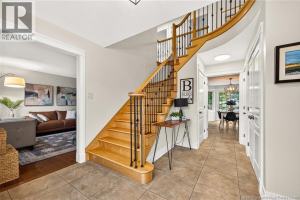View of the foyer, staircase, and hallway with access to living room and dining area. - 197 Mailhot Avenue, Moncton