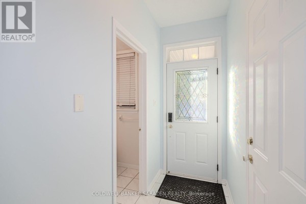 Interior view of a light blue entryway with a white door, tiled floor, and a closet. - 197 Portrush Avenue, Ottawa