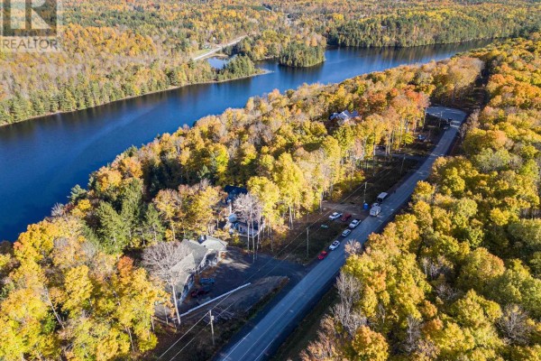 Aerial view of a winding road alongside a wide body of water with forested hills. - 197 Shady Maple Road, Mcnab/braeside