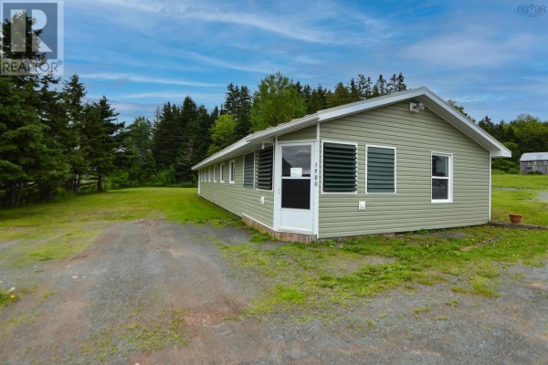 Exterior of a long, single-story green building with a white door and horizontal siding. - 1980 Highway 7, North Lochaber