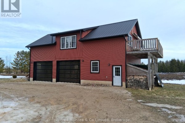 Red two-story garage with black roof and large doors. - 1984 Kincardine Kinloss Street, Huron Kinloss