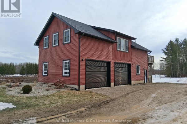 Side view of the red garage with landscaped area and driveway. - 1984 Kincardine Kinloss Street, Huron Kinloss