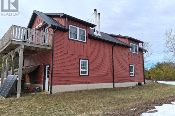 Close-up of the red garage featuring a balcony and solar panels. - 1984 Kincardine Kinloss Street, Huron Kinloss
