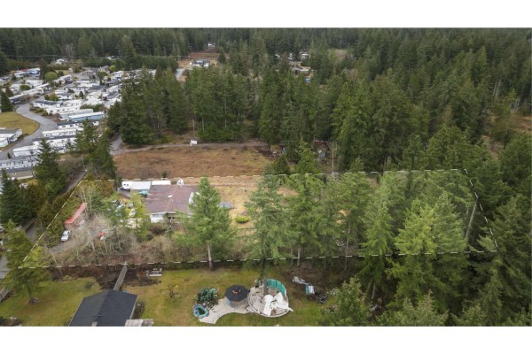 Aerial shot focusing on the property with adjacent homes and forested area. - 19840 30 Avenue, Langley