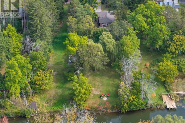 Aerial view of a large wooded property with a river and a dock. - 19842 Yonge Street, East Gwillimbury