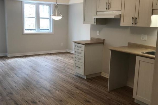 View of a dining area with a large window and adjacent kitchen cabinetry. - 1989 Ottawa Street S Unit# 28d, Kitchener
