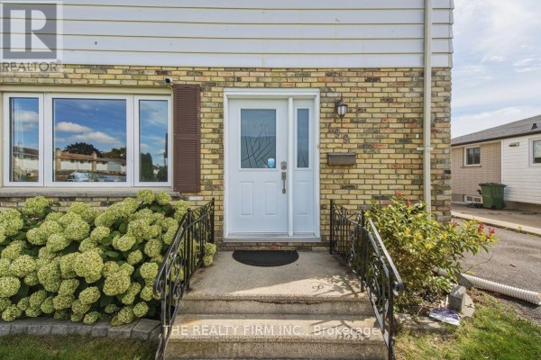 Close-up of the front door entrance with brick facade and steps. - 199 Highview Drive, St  Thomas