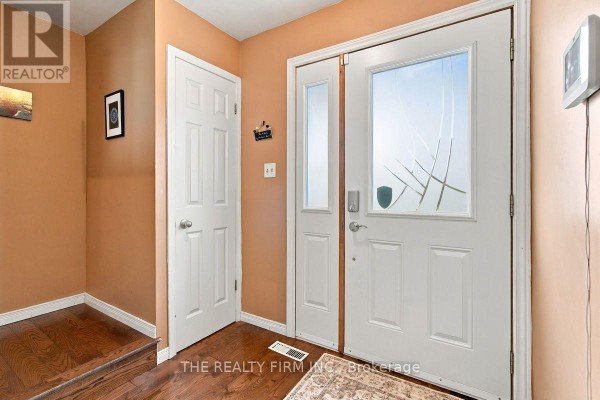 Interior view of a home entryway with double doors, wood flooring, and orange walls. - 199 Highview Drive, St  Thomas