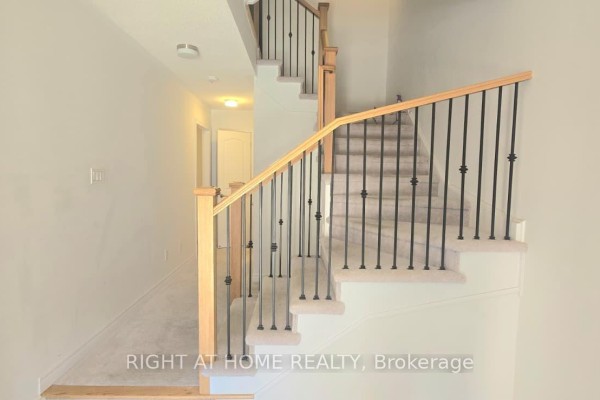 Close-up of carpeted stairs with wooden handrail and black metal spindles. - 1992 Cameron Lott Crescent, Oshawa