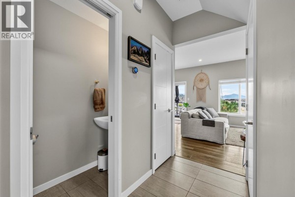 Hallway with a powder room entrance and view into the living room. - 1993 Qu'appelle Boulevard Unit# 120, Kamloops