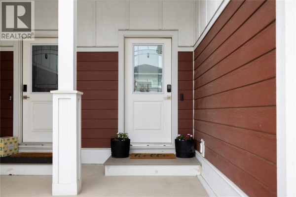 Close-up of the front door of townhouse unit #19 with glass pane and maroon siding. - 1999 15 Avenue Unit# 19, Vernon