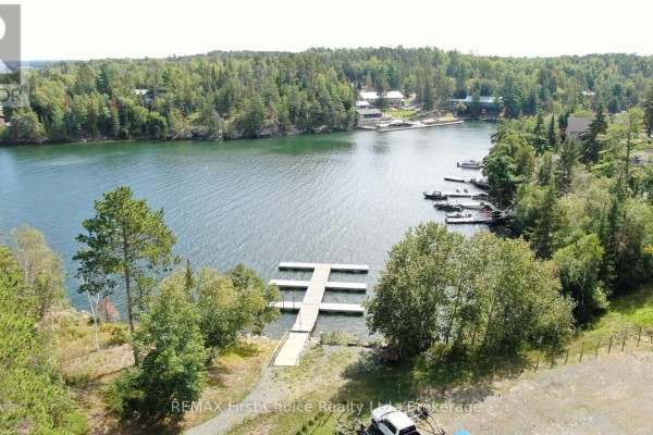 Gravel area with trees and a view of the bridge and nearby buildings - 19a Miller Road, Sioux Narrows Nestor Falls
