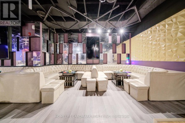 Nightclub atmosphere with neon lights, circular ceiling mirrors, and patrons at the bar and tables. - 1b - 2901 Kennedy Road, Toronto