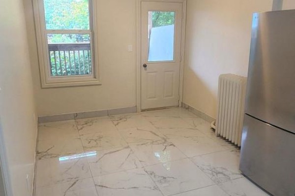 Room with white marble tile flooring, a window, a door, and a silver refrigerator. - 1b - 2nd Floor - 1030 St Clair Avenue, Toronto