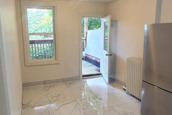 Room with white marble tile flooring, window, an open door to a balcony, and a silver refrigerator. - 1b - 2nd Floor - 1030 St Clair Avenue, Toronto