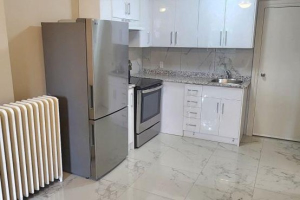 Kitchenette with white cabinetry, granite countertops, a stainless steel refrigerator, and stove. - 1b - 2nd Floor - 1030 St Clair Avenue, Toronto