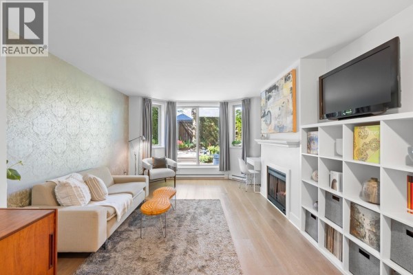 Living and dining area with white walls, hardwood floors, and garden view. - 1b 2775 Fir Street, Vancouver