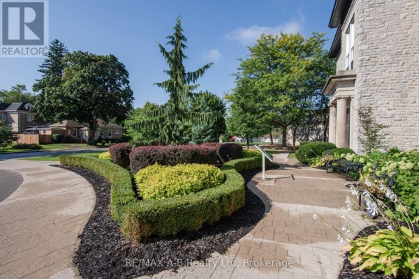 Courtyard area with paved walkways, manicured hedges, benches, and flowering plants. - 1c - 189 Elizabeth Street, St  Marys