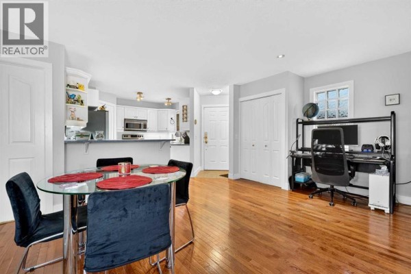 Dining area with a glass table and chairs, and a desk with a computer. - 2, 2811 24a Street Sw, Calgary