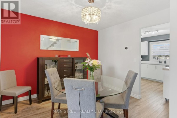 Dining room with glass table, upholstered chairs, chandelier, open to kitchen - 2 - 110 Silvan Drive, Welland