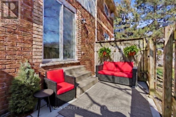 Patio with outdoor sofa, chair, wooden fence, and brick exterior - 2 - 110 Silvan Drive Welland