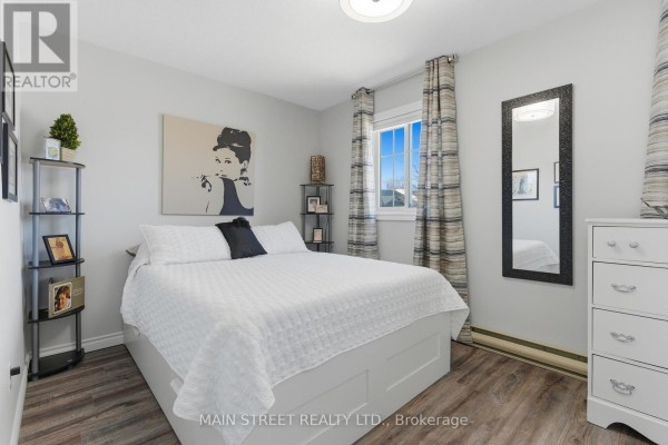 Renovated bedroom with bed, window, dresser, laminate flooring - 2 - 110 Silvan Drive, Welland