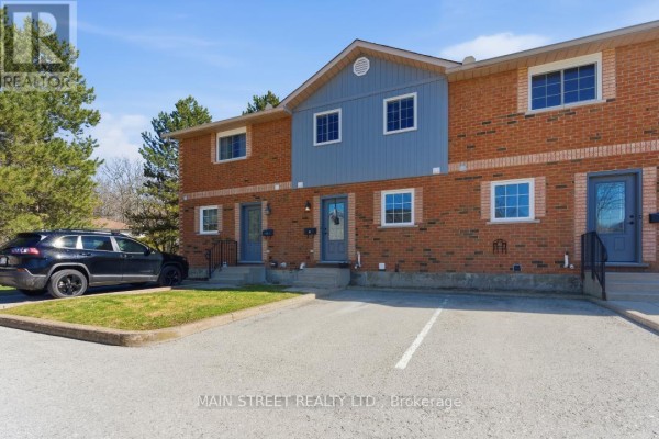 Townhouse exterior with brick, siding, multiple windows, paved parking - 2 - 110 Silvan Drive, Welland