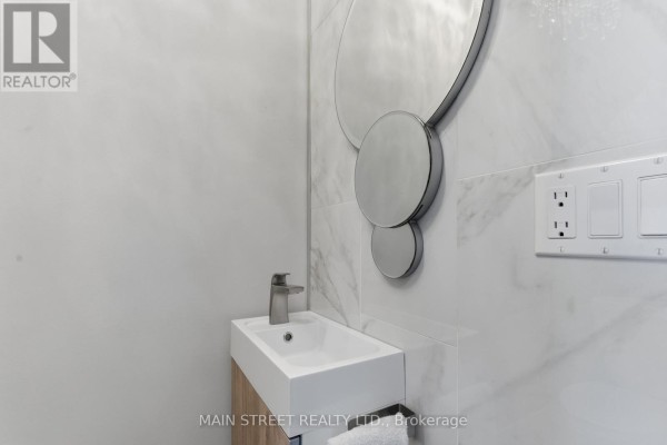 Modern bathroom with vanity sink, faucet, decorative mirror, tiled wall - 2 - 110 Silvan Drive, Welland