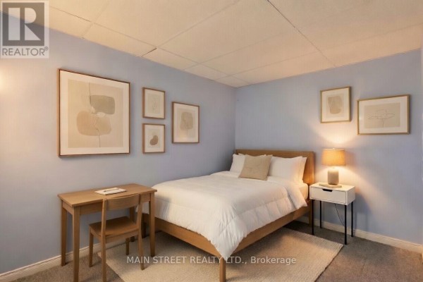 Bedroom with bed, desk, nightstand, drop ceiling, carpeted floor - 2 - 110 Silvan Drive, Welland